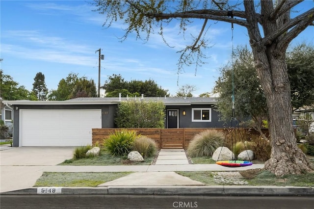 view of front of property with stucco siding, a garage, and a fenced front yard