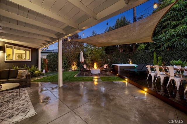 view of patio / terrace with a jacuzzi and an outdoor living space with a fire pit