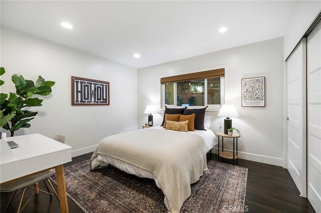 bedroom featuring recessed lighting, a closet, baseboards, and dark wood-type flooring