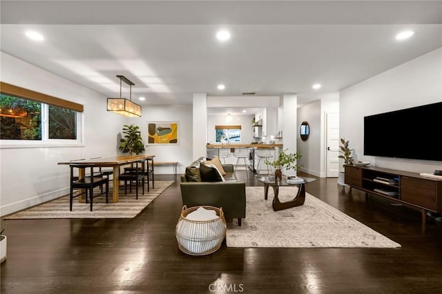 living area featuring recessed lighting, dark wood-style flooring, and baseboards