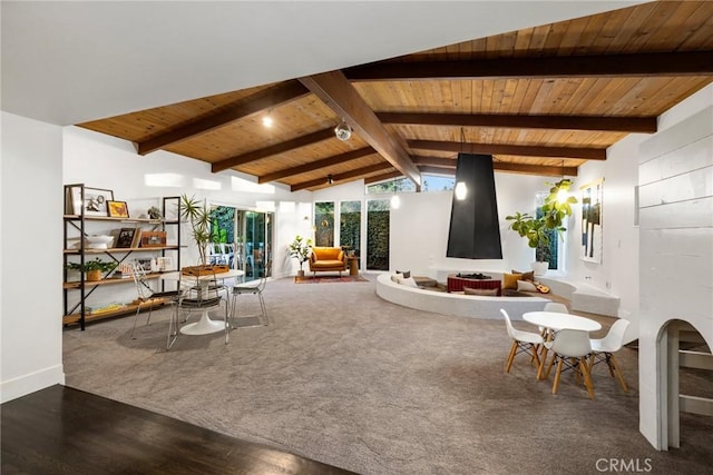 living area featuring lofted ceiling with beams, wood finished floors, and wooden ceiling