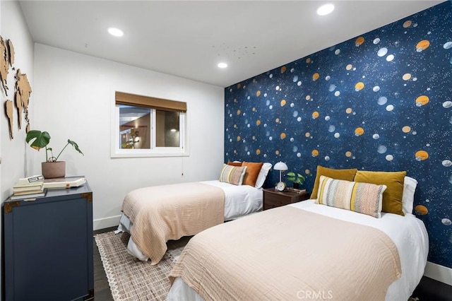 bedroom with an accent wall, recessed lighting, and wallpapered walls