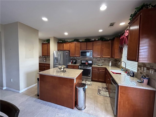 kitchen with recessed lighting, a sink, decorative backsplash, appliances with stainless steel finishes, and a center island