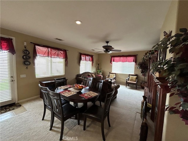 dining room featuring visible vents, baseboards, light colored carpet, and ceiling fan