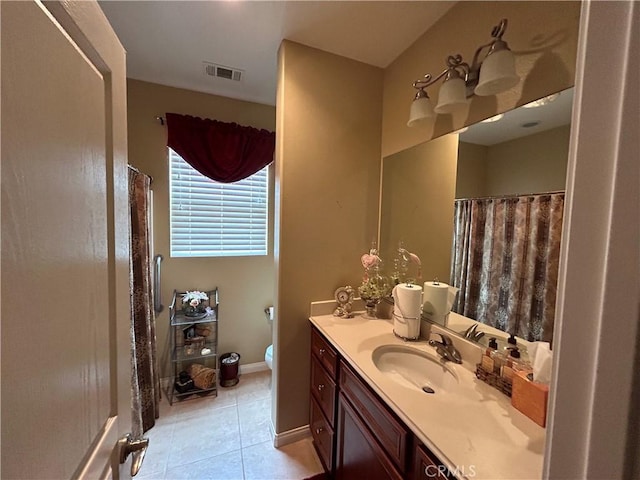 bathroom featuring vanity, visible vents, baseboards, tile patterned flooring, and toilet