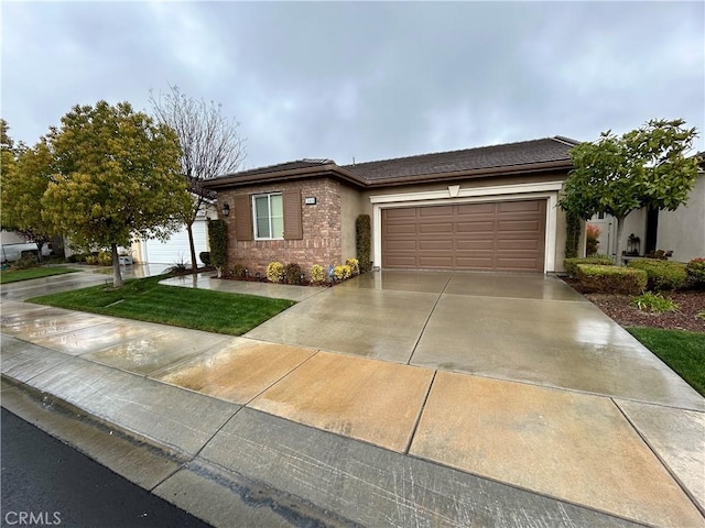 view of front of property with a garage, a tile roof, driveway, and stucco siding