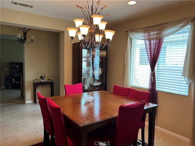 dining room with light tile patterned floors, baseboards, visible vents, and a chandelier