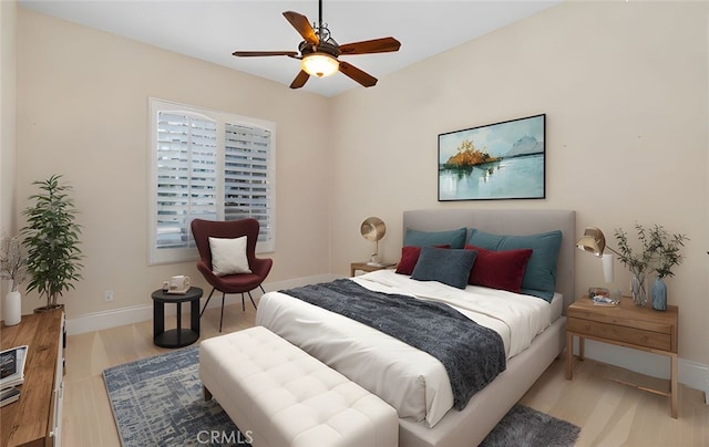 bedroom featuring baseboards, light wood-style floors, and a ceiling fan