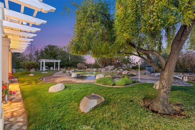 yard at dusk featuring an outdoor pool, a pergola, and a patio