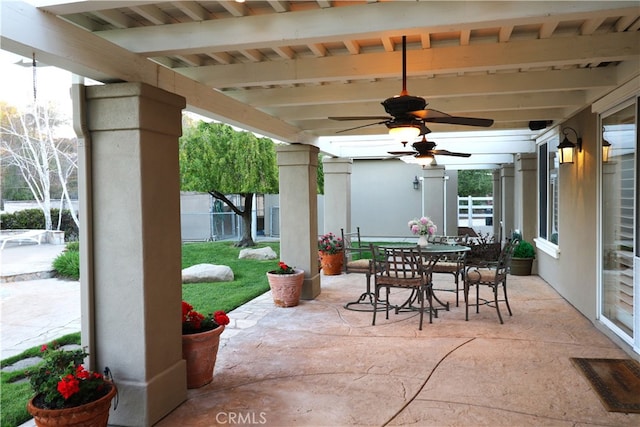 view of patio featuring a ceiling fan, outdoor dining area, and fence