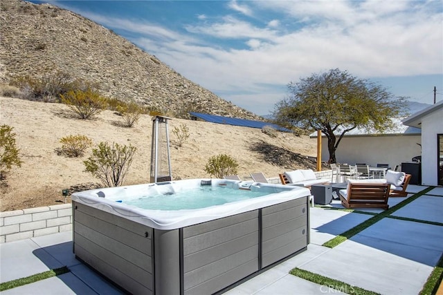 view of patio / terrace with an outdoor hangout area and a hot tub