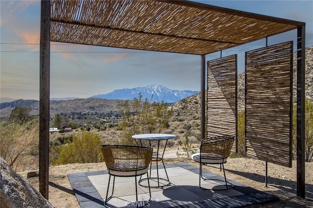 view of patio / terrace with a mountain view and an outdoor fire pit