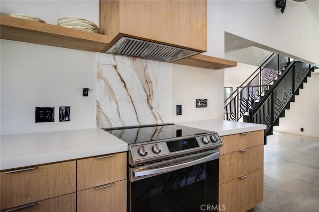 kitchen with electric range, tasteful backsplash, concrete flooring, and light countertops