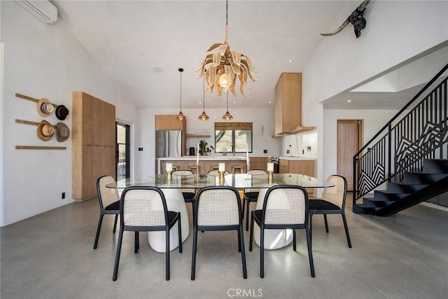 dining room with a wall mounted air conditioner, high vaulted ceiling, an inviting chandelier, and finished concrete flooring