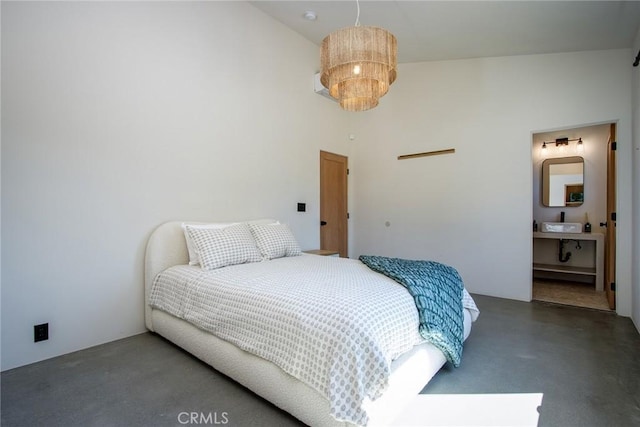 bedroom with a notable chandelier, concrete floors, and a towering ceiling