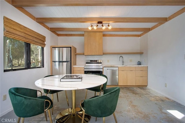 kitchen with beamed ceiling, light brown cabinetry, appliances with stainless steel finishes, light countertops, and baseboards