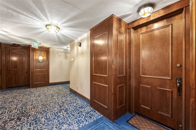 corridor with baseboards and a textured ceiling