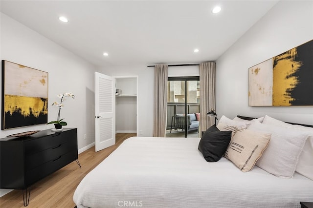 bedroom featuring a spacious closet, recessed lighting, light wood-style floors, and baseboards