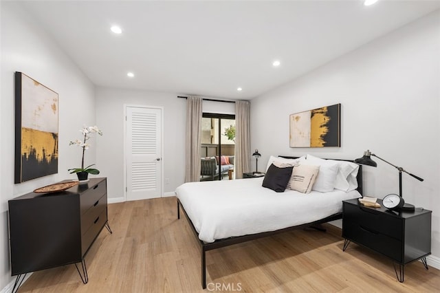 bedroom featuring recessed lighting, light wood-style floors, baseboards, and a closet