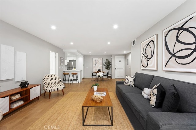 living room with visible vents, recessed lighting, and light wood-type flooring