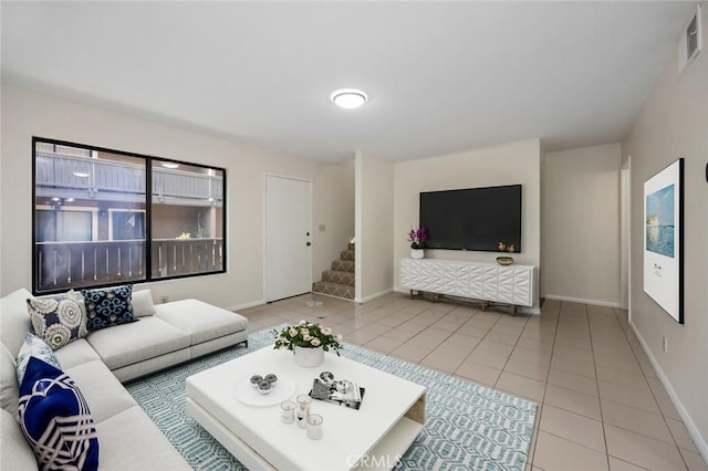 living area featuring tile patterned floors, visible vents, baseboards, and stairs