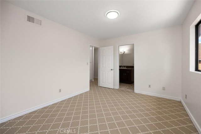 unfurnished bedroom featuring baseboards, visible vents, and connected bathroom