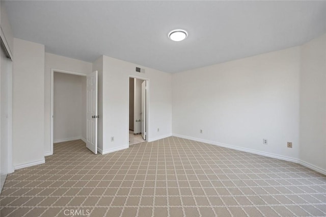 unfurnished room with visible vents and baseboards