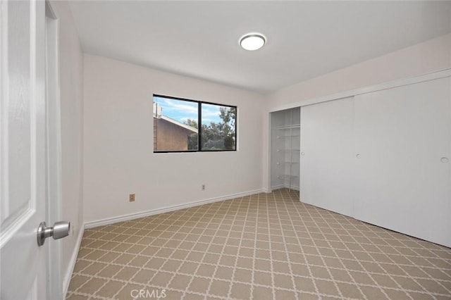 unfurnished bedroom with a closet and baseboards