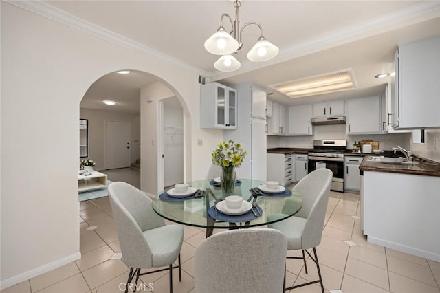 dining area with light tile patterned floors, visible vents, baseboards, arched walkways, and ornamental molding