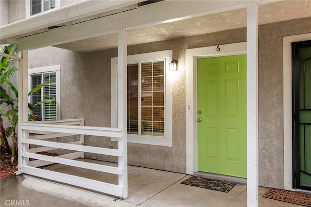 entrance to property featuring stucco siding