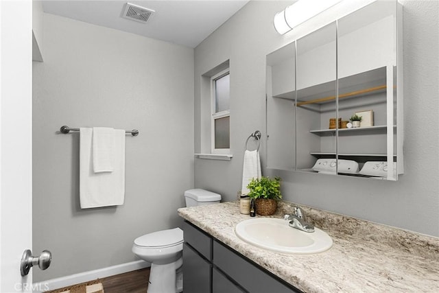 bathroom with visible vents, toilet, wood finished floors, baseboards, and vanity