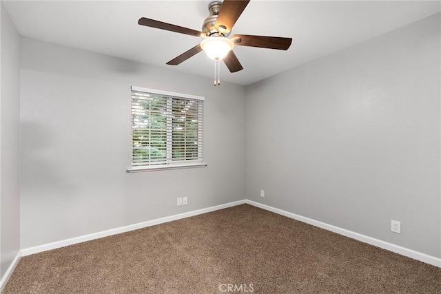 empty room with baseboards, a ceiling fan, and dark carpet