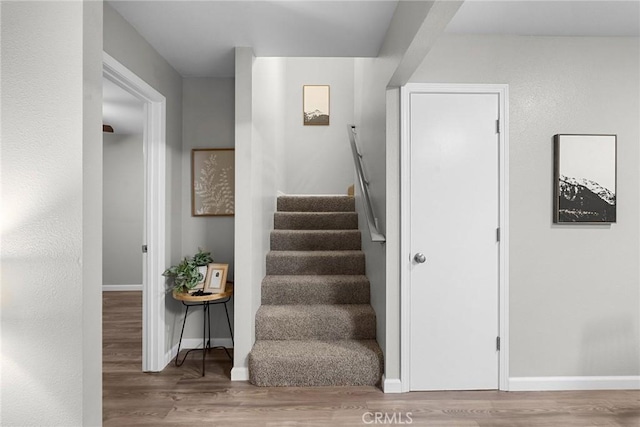 stairway featuring baseboards and wood finished floors