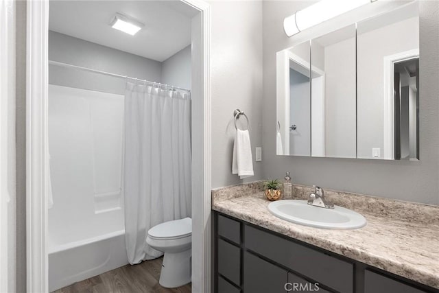 bathroom featuring toilet, shower / bath combo, wood finished floors, and vanity