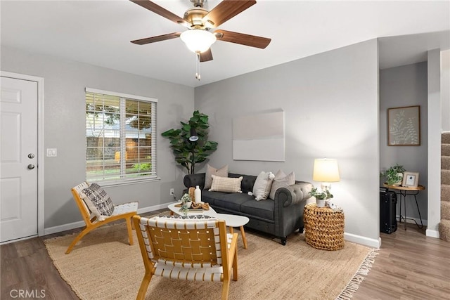 living area with stairs, baseboards, and wood finished floors