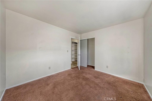 unfurnished bedroom featuring a closet, carpet flooring, and baseboards