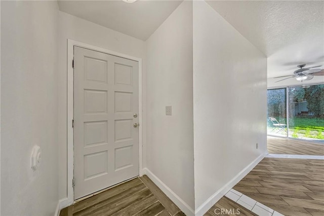 entrance foyer with baseboards, a textured ceiling, wood finished floors, and a ceiling fan