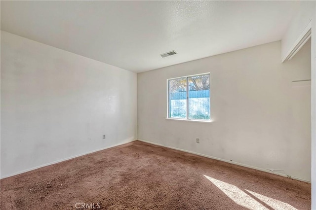 carpeted spare room featuring visible vents