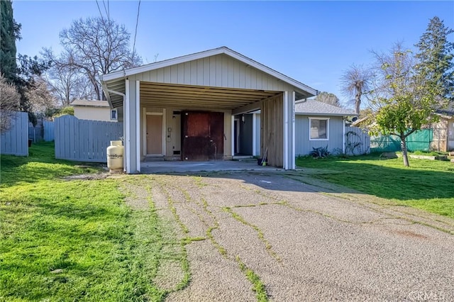 view of front facade featuring a front lawn, fence, and aphalt driveway