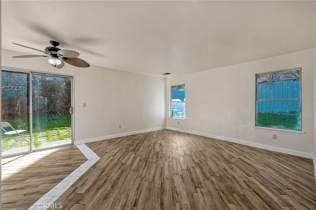 unfurnished room featuring ceiling fan, baseboards, and wood finished floors