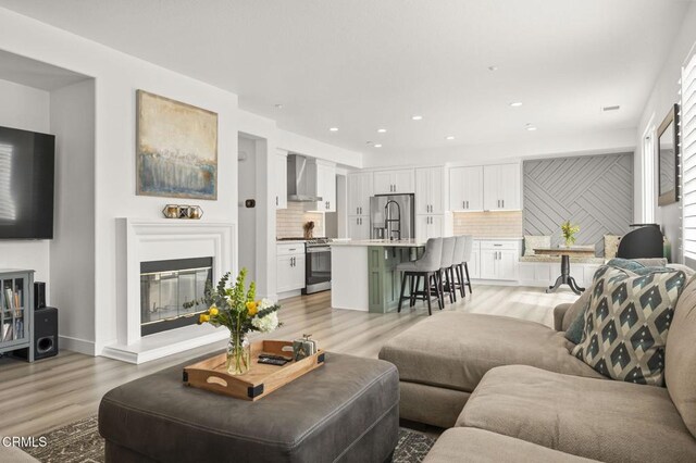 3012 Dunkirk Dr, Oxnard, CA 93035 - living room featuring recessed lighting, light wood-style floors, and a glass covered fireplace