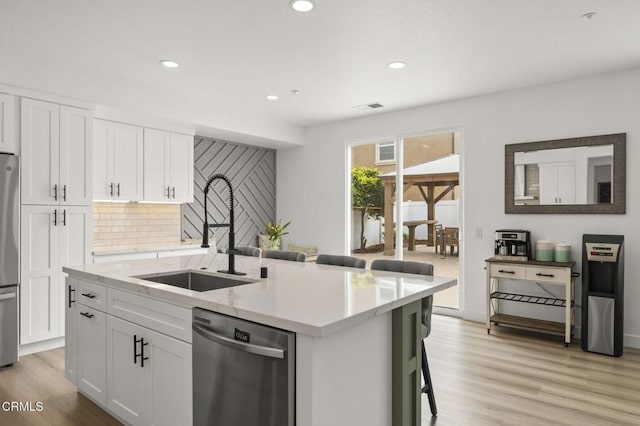 3012 Dunkirk Dr, Oxnard, CA 93035 - kitchen with a sink, stainless steel appliances, light wood-style floors, and white cabinetry