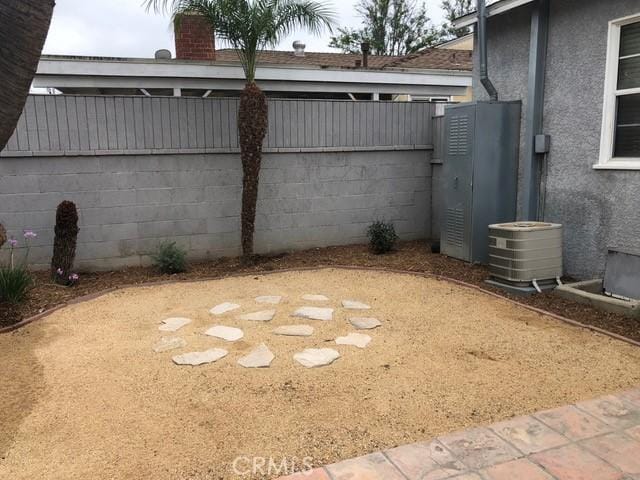 view of yard with cooling unit and fence