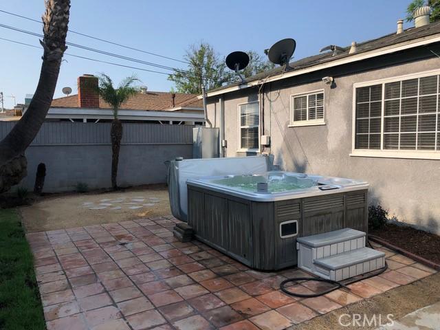 view of patio / terrace featuring a hot tub and fence