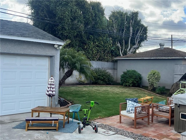 view of yard with a garage, fence, and a patio area