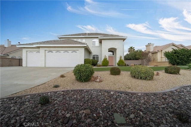 view of front of house featuring a garage, fence, concrete driveway, and stucco siding