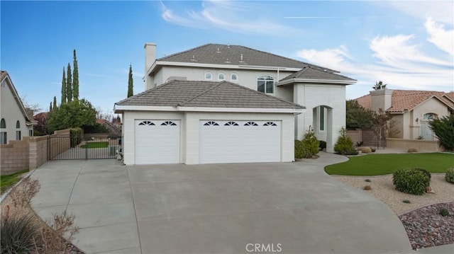 view of front of home with a tile roof, a gate, driveway, and an attached garage