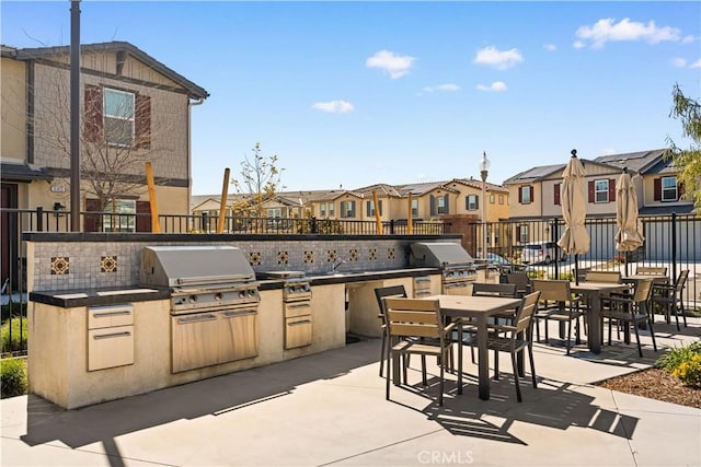 view of patio with area for grilling, exterior kitchen, and a residential view