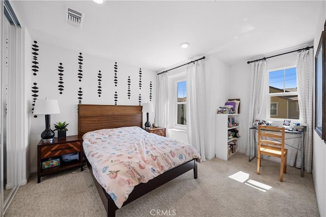 carpeted bedroom featuring visible vents