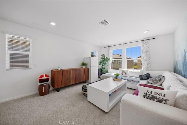 living room with baseboards, recessed lighting, visible vents, and light carpet